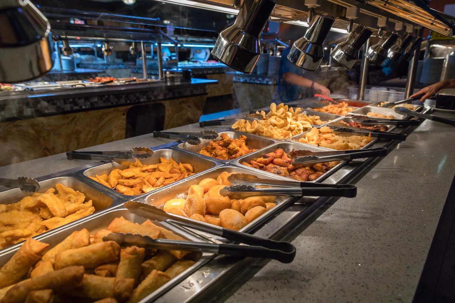 Hot buffet station with spring rolls, wontons, fried chicken, and appetizers