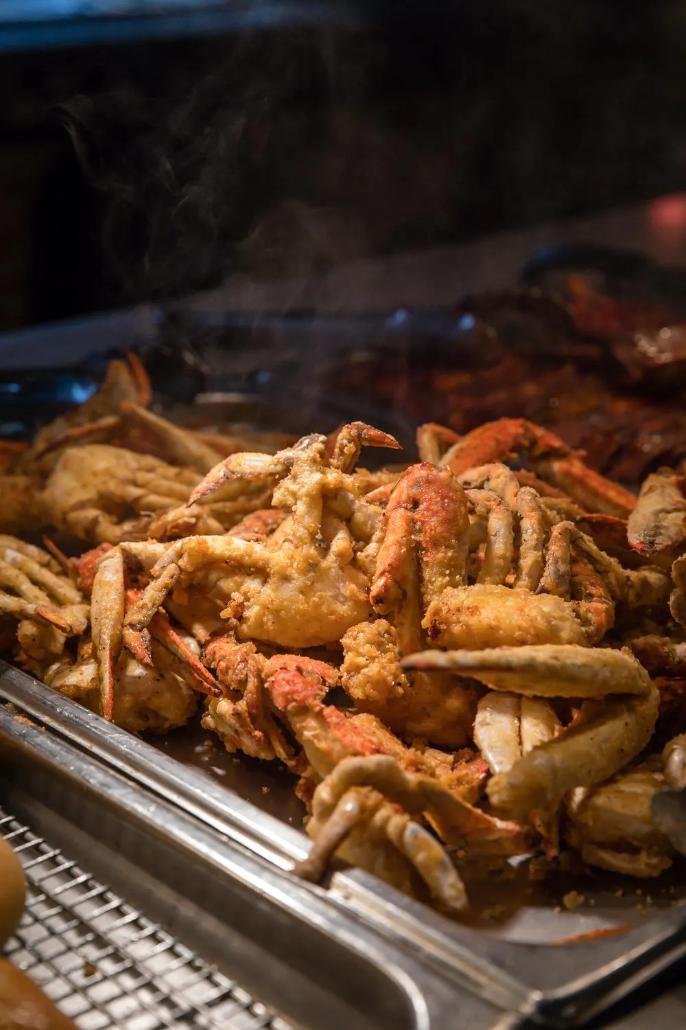 Tray of seasoned fried crab legs served hot at a seafood buffet